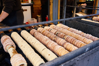 Process of baking trdelnik in prague, grilled rolled dough topped with sugar