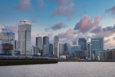 Modern buildings in city against cloudy sky