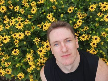 Portrait of man against yellow flowering plants