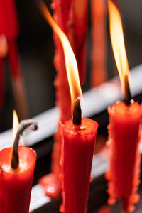 Close-up of lit candles on glass