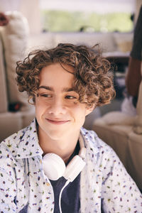 Close-up of thoughtful smiling man with headphones looking away in van