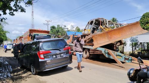 Cars on road against sky in city