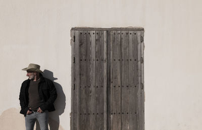 Portrait of adult man in cowboy hat and jeans against wall. almeria, spain