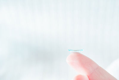 Close-up of hand holding umbrella against blurred background