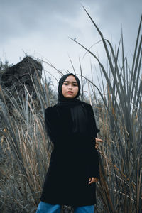 Woman standing on field against sky