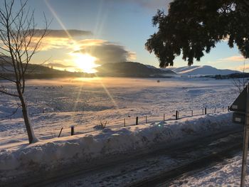 Scenic view of snow covered landscape against sky during sunset