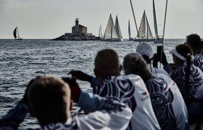 Rear view of people enjoying in sea