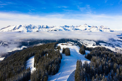 Scenic view of snow covered ski resort against sky