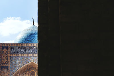 Birds by building against sky