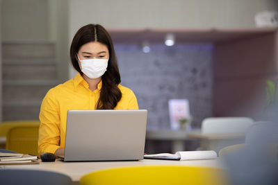 Businesswoman wearing mask working in office