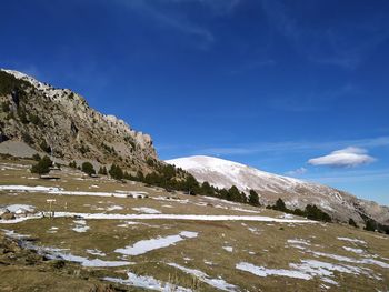 Scenic view of snowcapped mountains against blue sky