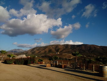 Road by mountains against sky