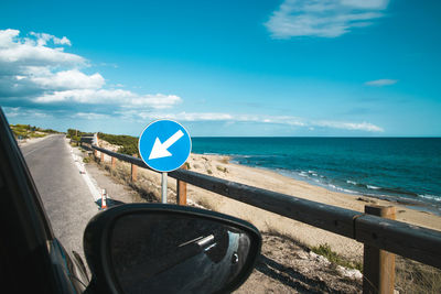 Cropped image of car at beach against sky