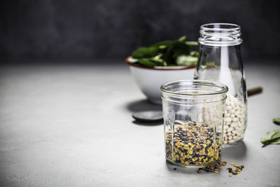 Close-up of food in jar on table against wall