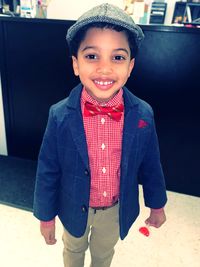 Portrait of smiling boy standing at home