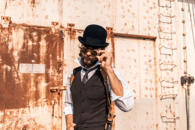 Full length of man photographing against wall