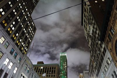 Low angle view of modern building against cloudy sky