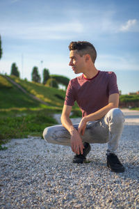Full length of man sitting on rock