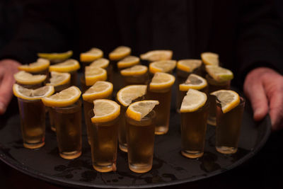 Midsection of waiter carrying tequila tray