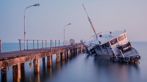 Panoramic view of abandoned ship in sea against clear sky