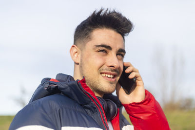 Smiling man looking away while talking over mobile phone