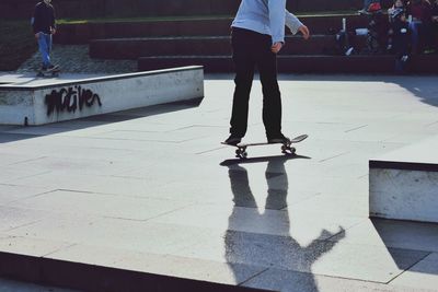 Low section of man skateboarding on tiled floor