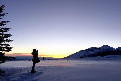 Full length of woman standing on snow covered landscape