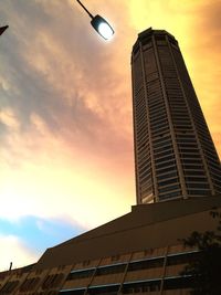 Low angle view of modern building against sky at sunset