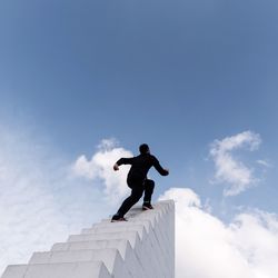 Low angle view of child standing against sky