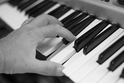 Cropped hand of man playing piano