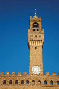 Tower with clock from the palazzo vecchio to the sunset. in the city of florence, italy.