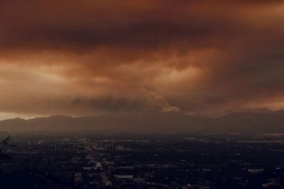 Aerial view of cityscape against cloudy sky
