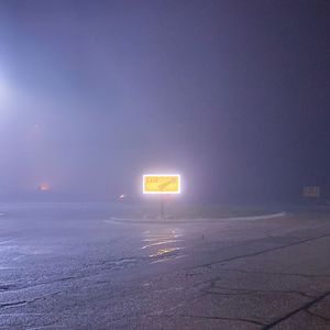 Illuminated road sign at night