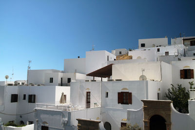 View of residential buildings against clear blue sky