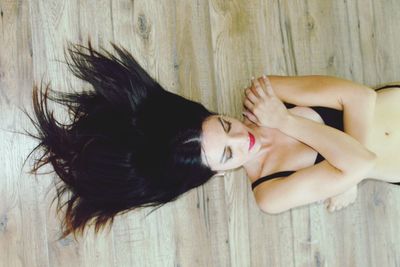 Directly above shot of beautiful woman lying on wooden floor