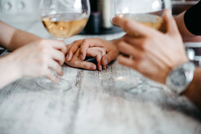 Sweet and romantic dinner. holding hands. two glasses of white wine. lovely couple. relationships 