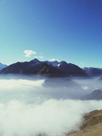 Scenic view of snowcapped mountains against blue sky
