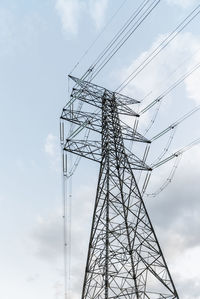 Low angle view of electricity pylon against sky