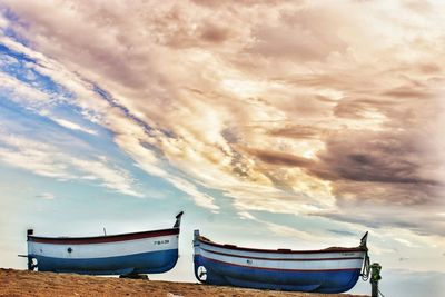 Boat moored on beach against sky