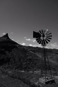 American-style windmill by mountain against sky
