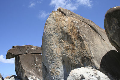 Low angle view of rocks against blue sky