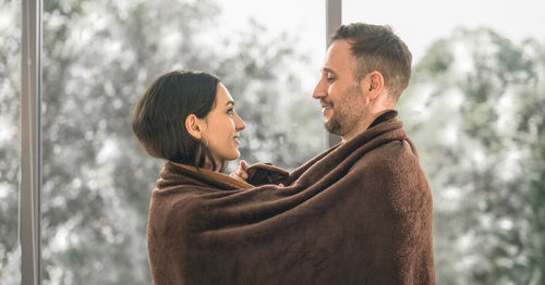 Side view of couple kissing against blurred background