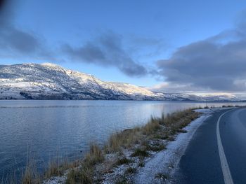 Scenic view of snowcapped mountains by lake against sky