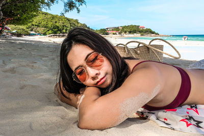 Portrait of woman lying down on beach