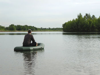 Rear view of man sitting in inflatable raft