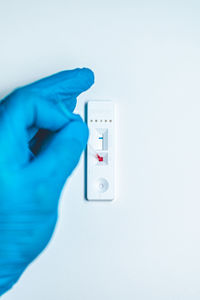 Close-up of hand holding camera against white background