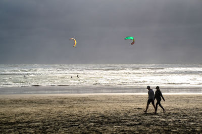 People on beach against sky