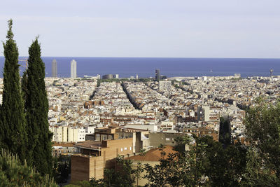 High angle view of townscape by sea against sky