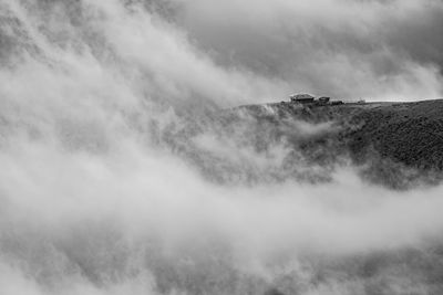 Scenic view of fog on mountain against sky