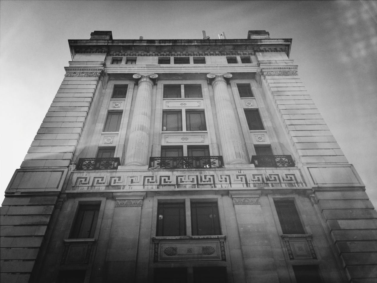 low angle view, architecture, building exterior, built structure, text, western script, window, sky, communication, city, building, day, no people, outdoors, capital letter, glass - material, information, non-western script, information sign, facade